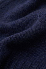 Close-up, detailed top-down view of the fine knit texture of the navy von Braun Cashmere beanie, showing its soft pure cashmere fabric and small turn-up. Whether worn with a classic winter coat or a highly functional down jacket, this soft VON BRAUN knitt