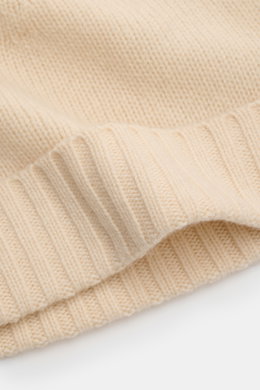 Close-up front angle of von Braun Cashmere beanie cream showing fine knit and small turn-up cuff, made of pure cashmere, very soft feel. Whether worn with a classic winter coat or a highly functional down jacket, this soft VON BRAUN knitted beanie made of