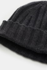 Nahaufnahme der von Braun Cashmere Mütze anthrazit meliert aus reinem mongolischem Cashmere, feines Rippstrickmuster, schmaler Umschlag, sehr weicher Griff, fotografiert von oben schräg.