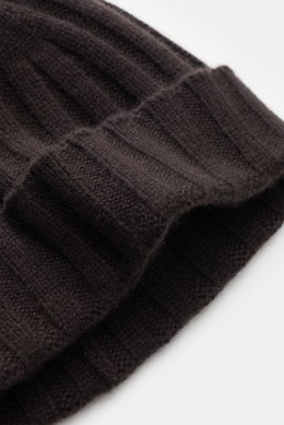 Nahaufnahme der von Braun Cashmere Mütze dunkelbraun mit klassischem Rippstrickmuster, schmalem Umschlag und feinem Strickbild aus reinem, sehr weichem mongolischem Cashmere, fotografiert von schräger Seite.