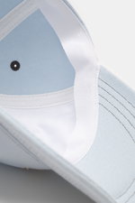 A.P.C. Baseball-Cap 'Charlie' pastellblau aus robustem Baumwoll-Canvas, Six-Panel-Design, tonales Logo-Stitching, verstellbarer Verschluss, Nahaufnahme von innen.