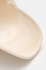 Nahaufnahme von der Unterseite des Schirms der A.P.C. Baseball-Cap 'Charlie' creme, robustes Baumwoll-Canvas, sportlich zeitlos.