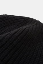 Close-up top-side view of the Stone Island Wool Beanie black showing its modern ribbed knit, wide cuff, and soft pure wool texture with the woven label.