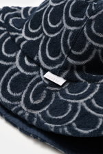 Nahaufnahme des 04651/ A trip in a bag Wende-Frottee Bucket Hat navy mit Baumwoll-Frottee, schmaler Krempe und kleinem Weblabel, seitliche Perspektive.
