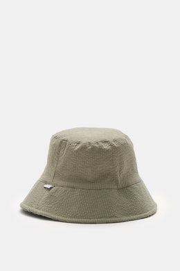 04651/ A trip in a bag Wende-Frottee Bucket Hat graugrün, schmale Krempe, Baumwoll-Frottee, Seersucker-Innenfutter, weiche Textur, seitliche Perspektive, wendbar.