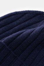 Close-up angled top view of Emporio Armani Beanie dark blue, showing fine knit pattern, wide rib knit, wide cuff, soft touch mix of wool and cashmere, and leather logo patch.