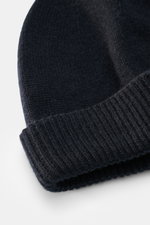 Close-up image of the Emporio Armani Cap navy photographed from above, showing a mix of cashmere and microfiber, soft touch, fine knit pattern, leather logo patch, and narrow cuff.