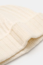 Close-up front-side view of the 04651/ A trip in a bag Cashmere Mütze creme, a luxurious winter accessory in cream with a soft feel, pure cashmere, wide cuff, medium knit pattern, and ribbed stitch.

Description: <p class="p1">Luxuriöses Winter-Accessoi