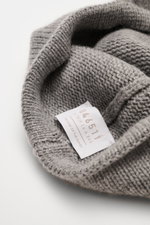 Close-up view of the inside label of the 04651/ A trip in a bag Cashmere Baseball-Cap grau meliert, showing fine, soft knit and craftsmanship.  
<p class="p1">Luxuriöses Winter-Highlight: Die Baseball-Cap aus der 'Look of the Games' Capsule von 04651/ A 