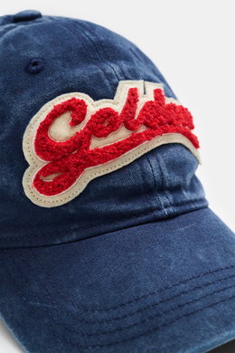 Golden Goose Baseball Cap grey blue shown from a close-up front angle, vintage twill cotton, soft touch, six-panel design, red star-shaped logo lettering, adjustable closure. Authentic style with personality: With its distinctive vintage design, this cap 