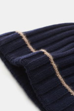 Close-up image of the Brunello Cucinelli Cashmere beanie navy, photographed from a side angle, showing its chic rib knit and decorative beige turn-up, made of pure cashmere for a soft touch and luxurious, casual warmth.