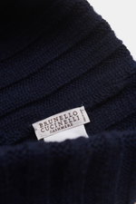 Close-up top-down view of the Brunello Cucinelli Cashmere beanie navy showing its pure cashmere, soft touch, fashionable rib knit, and decorative turn-up with label.