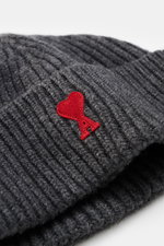 A close-up front-side view of the Ami Paris Beanie Dark Grey in heavy rib knit pure virgin wool with a wide cuff and red heart logo patch. Classic with heart: This beanie in heavy knit by AMI PARIS completes your look – for cool winter styles. Features pu
