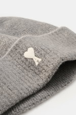 A close-up side view of the Ami Paris Beanie grey showcasing its classic rib knit pattern, wide cuff, and white heart logo patch, made of a soft mix of alpaca, wool, and microfiber for warmth and elasticity.