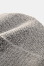 Close-up view of Ami Paris Beanie grey showing its soft, elastic rib knit texture made of alpaca, wool, and microfiber with a wide cuff and logo patch.