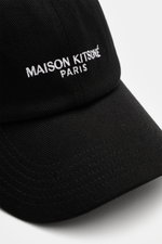 Nahaufnahme der Maison Kitsuné Baseball-Cap schwarz aus robuster Baumwoll-Twill mit strukturiertem Griff, Logo-Stitching, Sechs-Panel-Design, gebogenem Schirm und verstellbarem Verschluss, seitlich fotografiert.