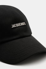 Nahaufnahme der Jacquemus Baseball-Cap schwarz aus reiner Baumwolle, leicht griffig, gebogener Schirm, Logo-Detail vorne, verstellbarer Verschluss, seitlich fotografiert.