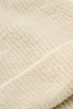 Close-up front view of the Massimo Osti Studio Beanie sand, showing mix of wool and microfiber, soft feel, classic rib knit pattern, and cuff with logo detail.