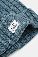 Close-up front-side view of C.P. Company Wool beanie smoky blue, made of pure virgin wool with a soft touch, classic rib knit pattern, medium coarse knit texture, and a cuff with logo patch.
