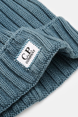 Close-up front-side view of C.P. Company Wool beanie smoky blue, made of pure virgin wool with a soft touch, classic rib knit pattern, medium coarse knit texture, and a cuff with logo patch.