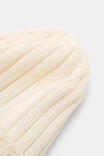 Close-up top view of the C.P. Company Merino beanie cream showing pure merino wool, soft feel, classic ribbed knit pattern, medium coarse knit texture, and cuff with logo patch.