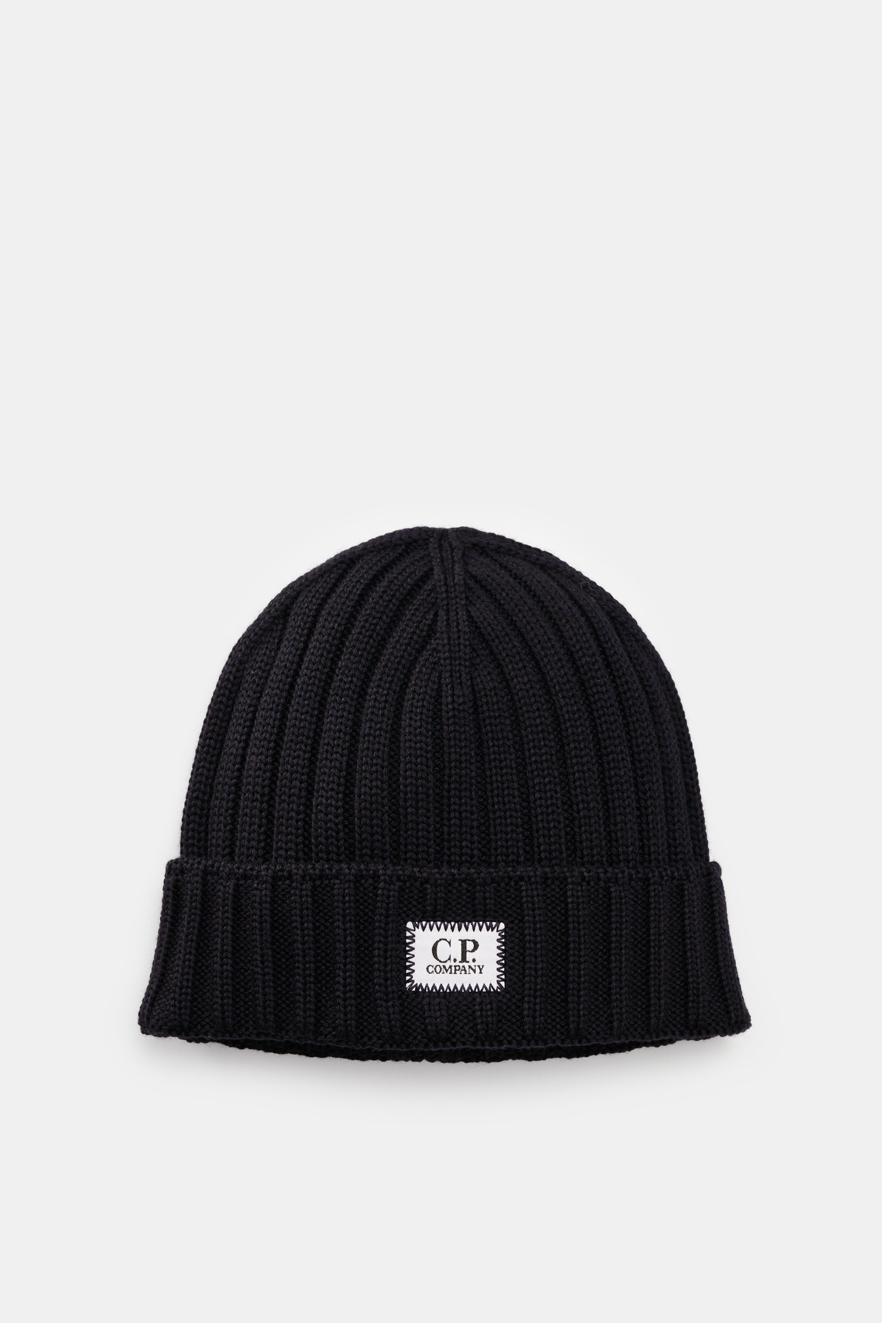 C.P. Company Merino Mütze dark navy, von oben fotografiert, reine Merinowolle, weicher Griff, klassisches Patentstrickmuster, mittelgrobes Strickbild, Umschlag mit Logo-Patch.