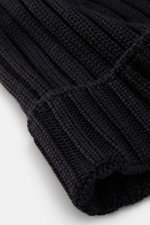 Close-up front angled view of C.P. Company Merino beanie dark navy, showing pure merino wool, soft feel, classic ribbed knit pattern, medium coarse knit texture, and cuff with logo patch.