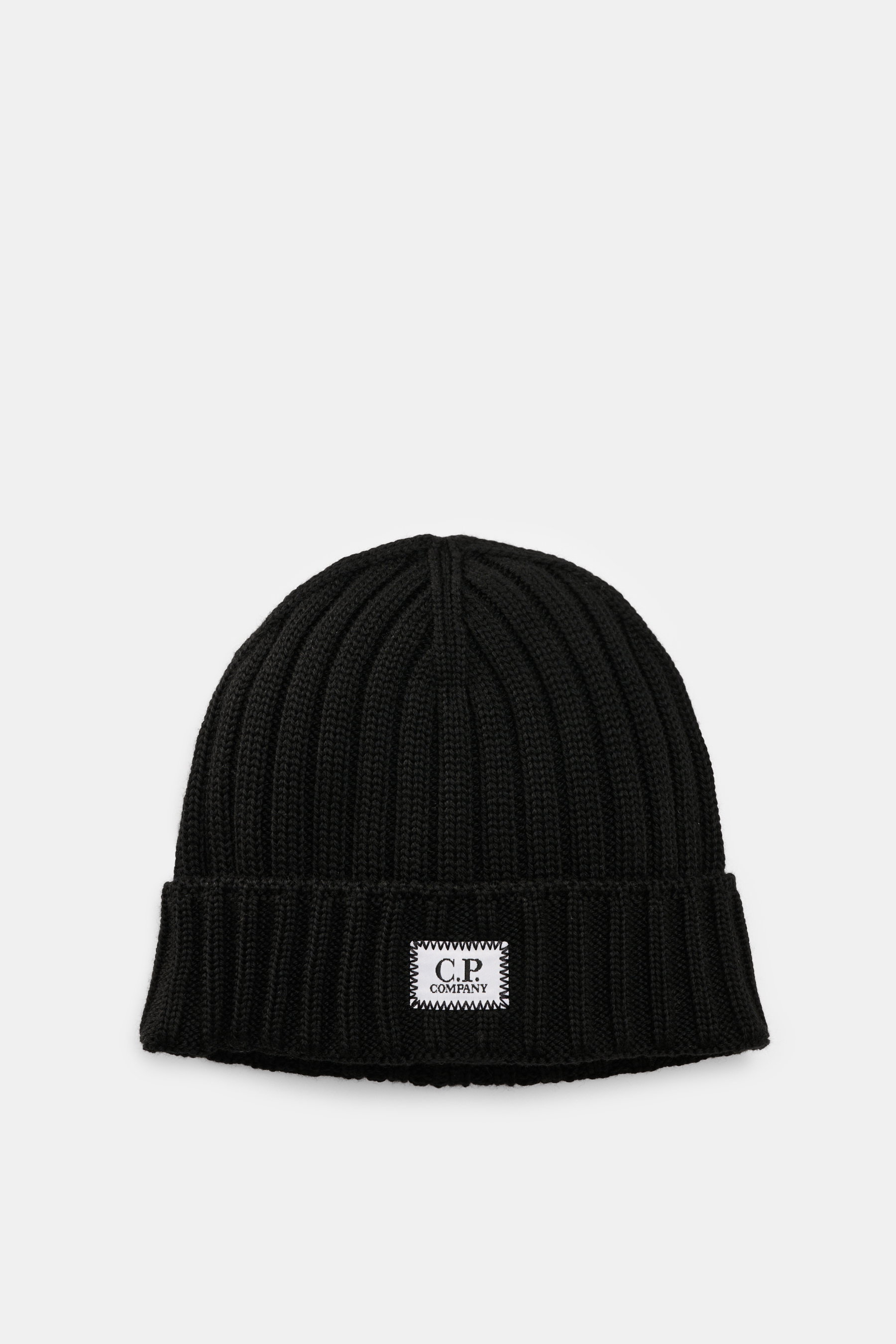 C.P. Company Merino Mütze schwarz, von oben fotografiert, reine Merinowolle, weicher Griff, klassisches Patentstrickmuster, mittelgrobes Strickbild, Umschlag mit Logo-Patch.