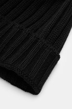 Close-up front angle of C.P. Company Merino Mütze black showing pure Merino wool, soft touch, classic patent stitch, medium knit texture, and folded cuff with logo patch.