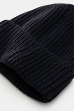 C.P. Company Wollmütze navy, Nahaufnahme von oben, reine Schurwolle, weicher Griff, klassisches Patentstrickmuster, mittelgrobes Strickbild, Umschlag mit Linsen-Detail.