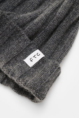Close-up top-side view of the FTC Cashmere Beanie dark grey showing ribbed knit pattern, narrow cuff with FTC woven label, pure cashmere, very soft feel, and medium-fine knit texture, a luxurious winter accessory.