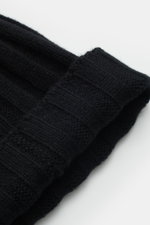 Close-up top-down view of the FTC Cashmere beanie black showing its rib knit brioche pattern, medium-fine pure cashmere knit, and folded variable brim with FTC woven label. Luxurious winter accessory with a very soft feel.