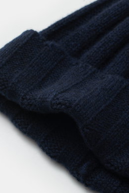 Nahaufnahme der FTC Cashmere Mütze navy aus feinstem Fair-Trade Cashmere mit Rippstrickmuster, schmalem Umschlag und FTC-Weblabel.