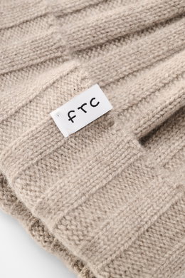 Close-up top view of the FTC Cashmere beanie sand showing its rib knit texture, medium-fine brioche pattern, and white woven FTC label on the variable brim, made from pure Fair Trade cashmere with a very soft feel.