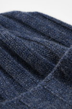 Close-up image of the FTC Cashmere Beanie grey blue showing its ribbed knit pattern and medium-fine texture from a top-down perspective, highlighting the pure cashmere material, very soft feel, and narrow cuff with FTC woven label.