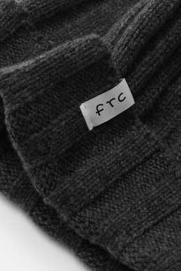 Nahaufnahme der FTC Cashmere Mütze anthrazit aus feinem Fair-Trade Cashmere mit Rippstrick und FTC-Label, schräg von oben fotografiert.