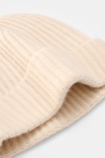 Moorer Cashmere Beanie "Davis-BC" cream shown close-up from above, featuring pure cashmere, very soft feel, rib stitch pattern, coarse knit structure.