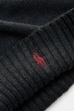Nahaufnahme der Polo Ralph Lauren Wollmütze anthrazit mit breitem Rippstrick-Umschlag und rotem Polospieler-Stitching aus reiner Wolle, weicher Griff, feiner Strick, seitliche Perspektive.