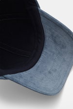 Innenansicht der 04651/ A trip in a bag Cord Baseball-Cap rauchblau, fotografiert aus seitlicher Perspektive, mit Cord aus elastischer Baumwolle, materialtypischem Griff, klassischem Six-Panel-Design und verstellbarem Verschluss.