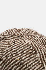 Nahaufnahme der braun/offwhite melierten 04651/ A trip in a bag Sailor Cap 'Fancy Twill' mit Six-Panel-Design, Mix aus Wolle und Microfaser, materialtypischem Griff und verstellbarem Verschluss, von oben fotografiert.