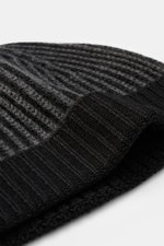 Close-up image from a side angle of the 04651/ A trip in a bag Wool Hat 'Foggy' black/dark grey, showing pure virgin wool, patent knit, soft touch, medium coarse knit pattern, and narrow cuff.