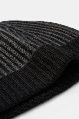 Close-up image from a side angle of the 04651/ A trip in a bag Wool Hat 'Foggy' black/dark grey, showing pure virgin wool, patent knit, soft touch, medium coarse knit pattern, and narrow cuff.
