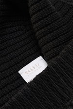 Close-up front view of 04651/ A trip in a bag Wool Hat 'Foggy' black/dark grey showing pure virgin wool, patent knit, soft touch, medium coarse knit pattern, narrow cuff.