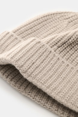Nahaufnahme der 04651/ A trip in a bag Cashmere Mütze taupe mit breitem Umschlag, mittelfeinem Strickbild und markantem Patentstrickmuster aus weichem, reinem Cashmere, fotografiert aus schräger Perspektive.