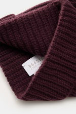 Nahaufnahme aus schräger Perspektive der dunkelvioletten 04651/ A trip in a bag Cashmere Mütze mit breitem Umschlag und markantem Patentstrickmuster.