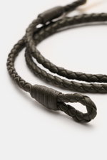 Tom Ford Armband dunkelbraun/gold, schmal geflochtenes Glattleder mit Schlaufenverschluss, goldfarbener T-Verschluss, Nahaufnahme schräg von oben.