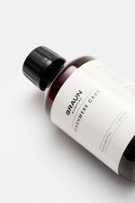 BRAUN Hamburg Waschmittel 'Cashmere Care' 100 ml bottle photographed from a top-side angle on a white surface, with a peach-scented formula for wool and cashmere care. Hochwertige Pflege für Ihre Cashmere- und Wollprodukte: Das 'Cashmere Care' Waschmittel