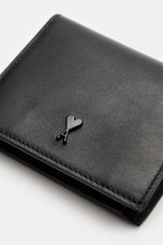 Ami Paris Portemonnaie schwarz aus fein genarbtem Kalbleder, Frontlogo, vier Kartenfächer, Münzfach mit Druckknopf, Seitenperspektive.