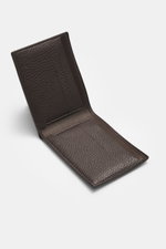 The Row Portemonnaie 'Classic Wallet' dunkelbraun in Nahaufnahme von schräg oben gezeigt, fein genarbtes Leder, sechs Kartenfächer, Banknotenfach, geprägtes Logo, Maße ca. 11x8,5 cm.
