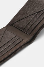 The Row Portemonnaie 'Classic Wallet' dunkelbraun aus fein genarbtem Leder, offen fotografiert, zeigt sechs Kartensteckfächer, ein Banknotenfach und ein geprägtes Logo.